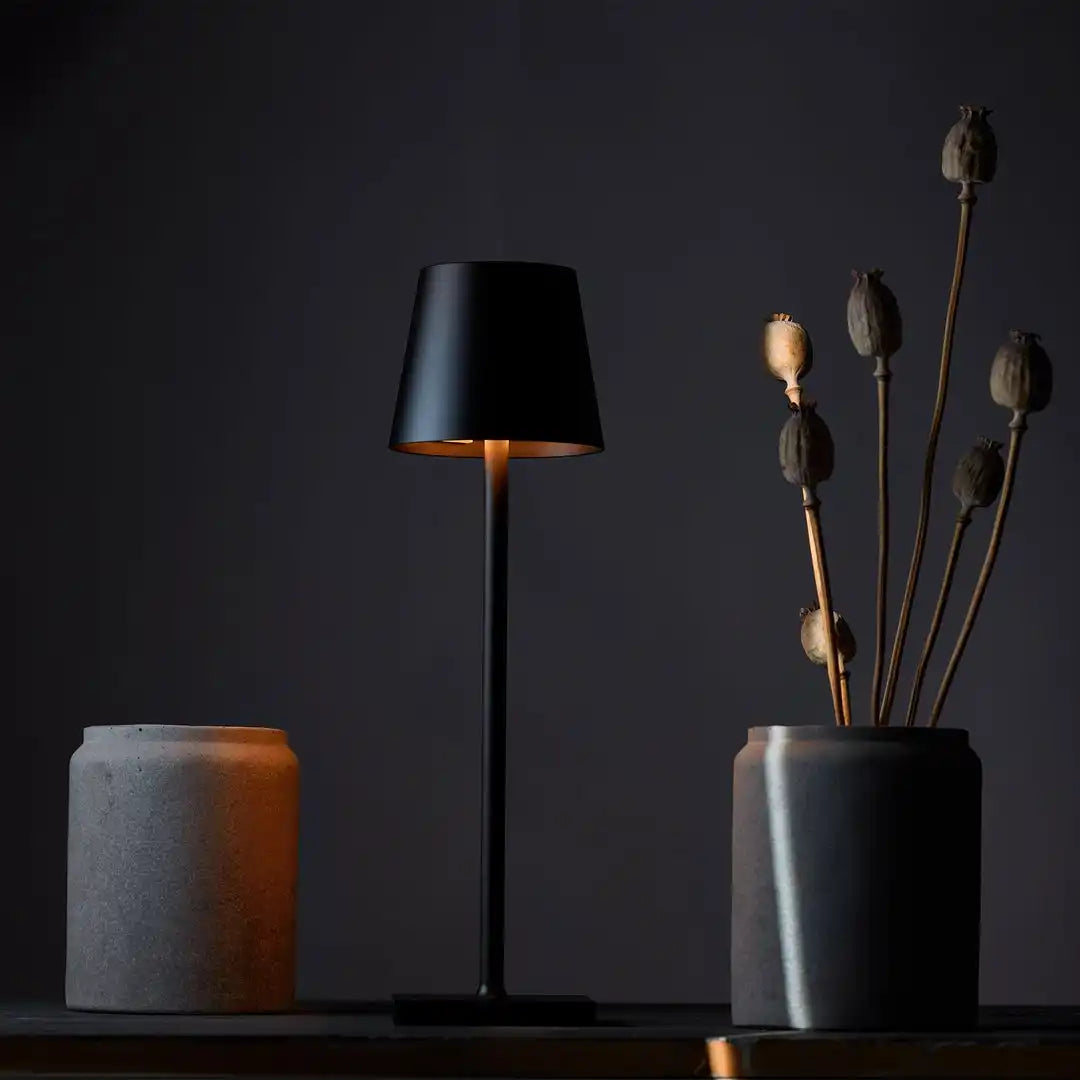 A black table lamp with a glowing interior.