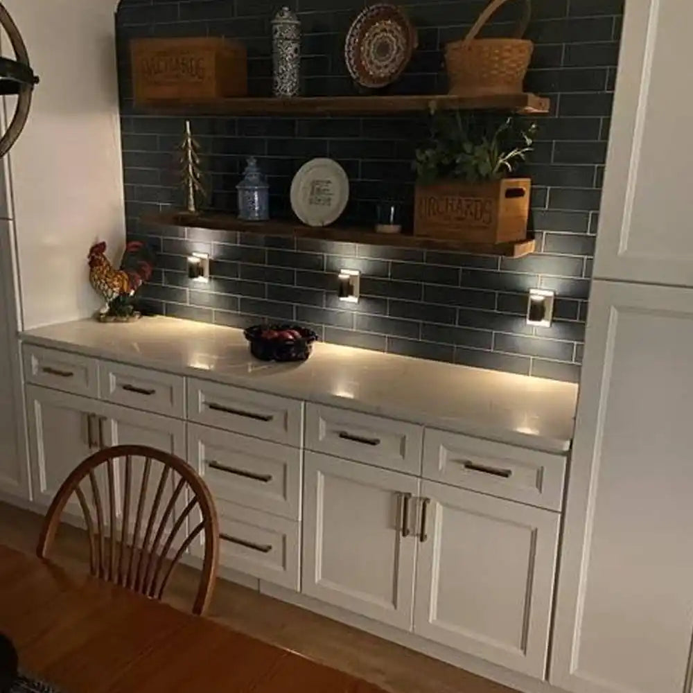 A built-in kitchen hutch with dark subway tile backsplash, two wooden floating shelves, and white base cabinets with a light countertop.