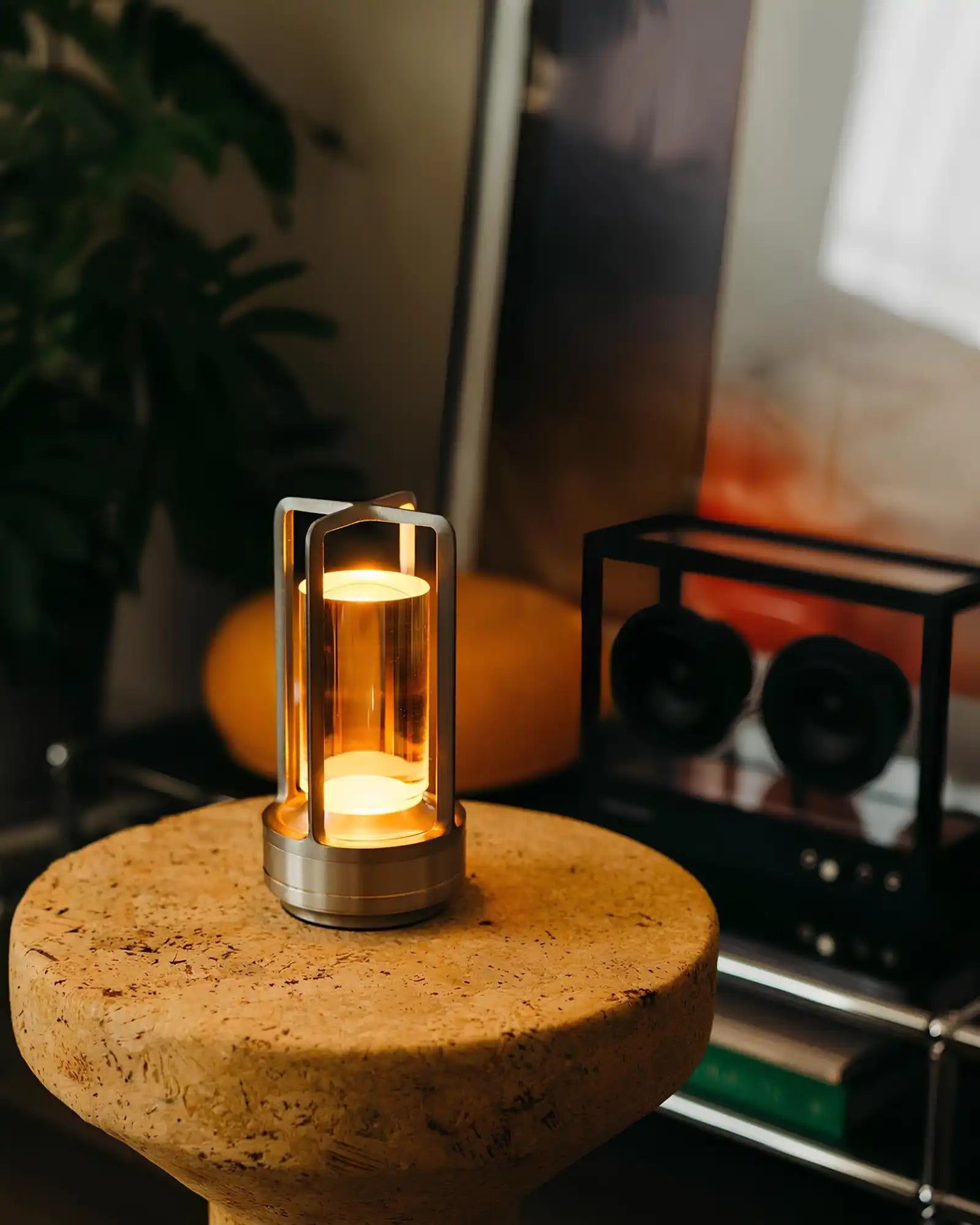 A modern, cylindrical lantern with warm, glowing light.
